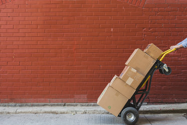 Shipping boxes stacked in front of a red brick wall